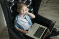 Young businessman using a laptop. funny child in glasses. Fashion portrait of little handsome boy in office Royalty Free Stock Photo