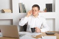 Young businessman using laptop at home. Young man working on computer at his house. Casual entrepreneur feeling excited about new Royalty Free Stock Photo