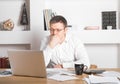 Young businessman using laptop at home. Man working on computer at house. Casual entrepreneur feeling excited about new project Royalty Free Stock Photo