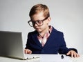 Young businessman using a laptop. Serious child in glasses