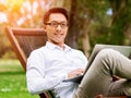 Young businessman using laptop while sitting outdoors Royalty Free Stock Photo