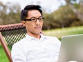 Young businessman using laptop while sitting outdoors Royalty Free Stock Photo