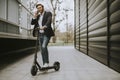 Young businessman using mobile phone  on electric scooter Royalty Free Stock Photo