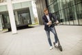 Young businessman using mobile phone on electric scooter Royalty Free Stock Photo