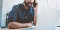 Young businessman using smartphone at office and making notes.Blurred background.Horizontal wide.Cropped.