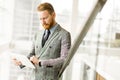 Young businessman using tablet and looking at his watch Royalty Free Stock Photo