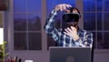 Young businessman using virtual reality goggles at night in his home office Royalty Free Stock Photo