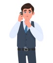 Young businessman in waistcoat speaking on the phone and asking silence. Trendy person calling to mobile, keeping finger on lips. Royalty Free Stock Photo