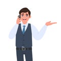 Young businessman in waistcoat speaking on the phone and presenting hand to copy space. Trendy person calling to mobile, Royalty Free Stock Photo