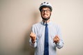 Young businessman wearing glasses and bike helmet standing over isolated white bakground very happy and excited doing winner Royalty Free Stock Photo