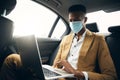 Young Businessman Wearing Mask Working On Laptop In Back Of Taxi Royalty Free Stock Photo