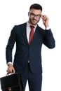 Businessman holding briefcase and fixing glasses happy Royalty Free Stock Photo