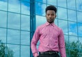 Young businessman wearing pink shirt glass office building background