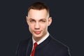 Young businessman wearing suite standing over dark background. Studio shot Royalty Free Stock Photo