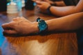 businessman wearing wrist watch on his arm. while staying in meeting room have ceramic glass and wooden work table are background Royalty Free Stock Photo