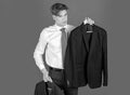 Young businessman in white shirt and tie, shop assistant present formal jacket outfit on hanger, choice and success Royalty Free Stock Photo