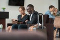 Young businessman and woman waiting at airport lounge or hotel lobby and working with tablet PC Royalty Free Stock Photo