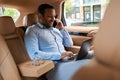 Young businessman working on computer in car