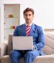 The young businessman working at home sitting on the sofa Royalty Free Stock Photo