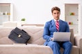 The young businessman working at home sitting on the sofa Royalty Free Stock Photo