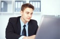 Young businessman working on laptop in office