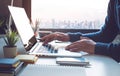 Young businessman working on laptop in office with window city view Royalty Free Stock Photo