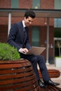 Young businessman working on laptop outside the office