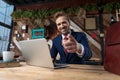 Young businessman working on laptop and pointing finger Royalty Free Stock Photo