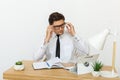 Young businessman working in office, sitting at desk