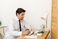 Young businessman working in office, sitting at desk