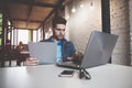 Young businessman working in office, sitting at desk, looking at laptop computer screen, smiling Royalty Free Stock Photo