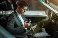 Young businessman works in his car using his laptop and smartphone getting ready for important meetting with partners, Royalty Free Stock Photo