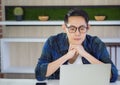 Young businessman is worried after looking at reports on the laptop screen. Anxiety causes stress concerns from work problems.