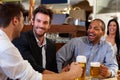 Young businessmen drinking beer at pub
