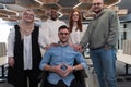 Young businessmen in a modern office extend a handshake to their business colleague in a wheelchair, showcasing