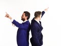 Young businessmen pointing in two different directions at same time. Royalty Free Stock Photo