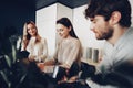 Young businesspeople colleagues having a coffee break in office, drinking and talking Royalty Free Stock Photo
