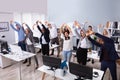 Young Businesspeople Doing Stretching Exercise At Workplace Royalty Free Stock Photo