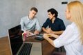 Young businesspeople having business meeting at table in boardroom using laptop. Millennial business team discussing Royalty Free Stock Photo