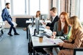 young businesss ladies sitting in modern office and using computer, discussing