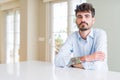 Young businesss man sitting on white table Relaxed with serious expression on face