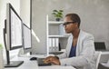 Young businesswoman or accountant sitting at office desk and working on computers Royalty Free Stock Photo