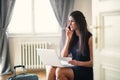 Young businesswoman on a business trip sitting in a hotel room, using laptop. Royalty Free Stock Photo