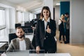 Young businesswoman and businessman working together in office. Beautiful office girl showing thumb up Royalty Free Stock Photo