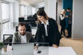 Young businesswoman and businessman working together with office workers on background in modern office Royalty Free Stock Photo