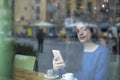 Young businesswoman in a cafe- seen through window Royalty Free Stock Photo