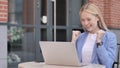 Young Businesswoman Celebrating on Laptop Sitting Outside Office Royalty Free Stock Photo