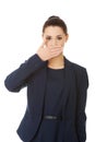 Young businesswoman covering with hand her mouth