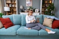 Young businesswoman cryptocurrency trader sitting in home office working on tablet while sitting on sofa. Freelance female global Royalty Free Stock Photo