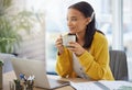 Coffee gives me motivation. a young businesswoman drinking coffee in a modern office at work.